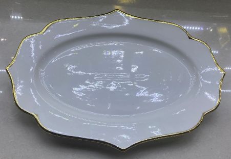 White oval platter with a wavy gold rim
