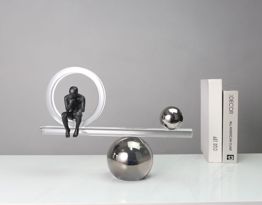 Thinker figure on a balance bar