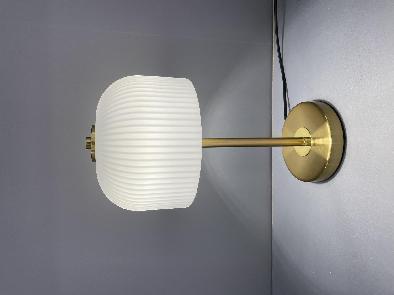 Lamp with a ribbed white shade and gold arm