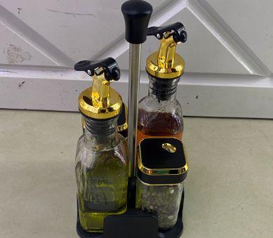 Seasoning bottles with gold tops and a stand