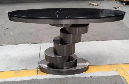Console with a black marble-look top on a spiral base