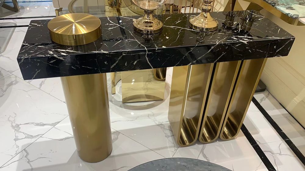 Console with a black marble-look top on gold legs, 120 × 35 cm